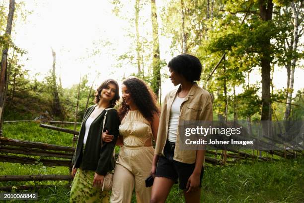 young female friends walking in nature - promenade stockfoto's en -beelden