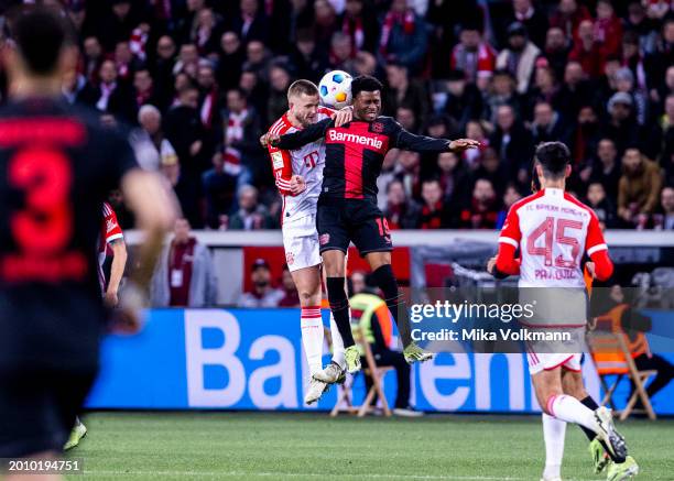 Eric Dier of Muenchen jumps for a header against Nathan Tella of Leverkusen during the Bundesliga match between Bayer 04 Leverkusen and FC Bayern...