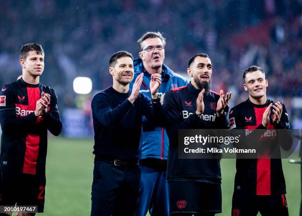 Head coach Xabi Alonso of Leverkusen and Florian Wirtz of Leverkusen celebartes the victory with fans during the Bundesliga match between Bayer 04...