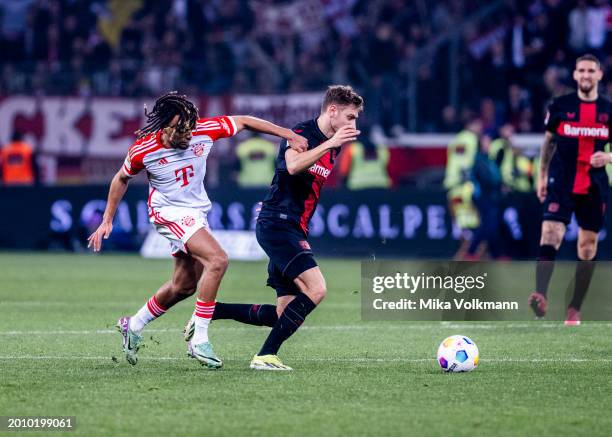 Sacha Boey of Muenchen challenges Josip Stanisic of Leverkusen during the Bundesliga match between Bayer 04 Leverkusen and FC Bayern Muenchen at...