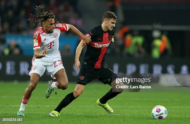 Sacha Boey of Muenchen challenges Josip Stanisic of Bayer Leverkusen during the Bundesliga match between Bayer 04 Leverkusen and FC Bayern München at...