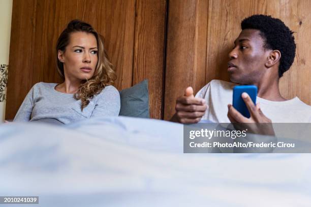 adult couple arguing while lying on bed - deshonestidad fotografías e imágenes de stock