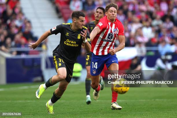 Las Palmas' Spanish defender Mika Marmol is challenged by Atletico Madrid's Spanish midfielder Marcos Llorente during the Spanish league football...