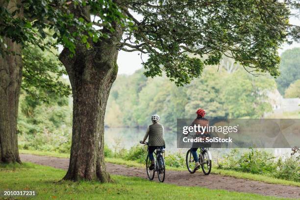 cycling through the park - riserva naturale foto e immagini stock