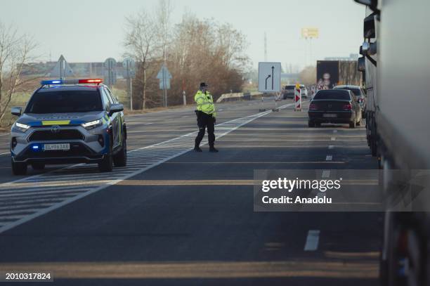 Police officer talks on her phone as around a thousand, mostly Ukrainian trucks wait in kilometre-long lines after Polish farmers closed off the...