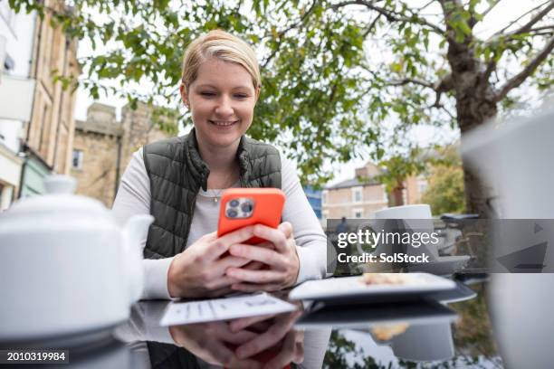 using an app at a cafe - lesbian dating stockfoto's en -beelden