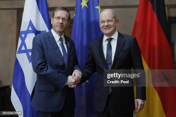 German Chancellor Olaf Scholz and Israeli President Isaac Herzog shake hands as they pose for media during bilateral talks at the 'Bayerischer Hof'...