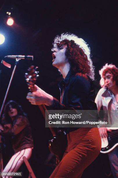 Singer and guitarist Marc Bolan of English rock band T Rex performs live on stage with, behind, percussionist Mickey Finn and bassist Steve Currie,...