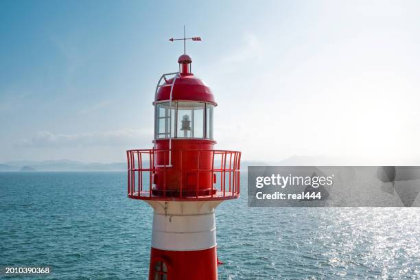 partly sunlit lighthouse - red beacon stock pictures, royalty-free photos & images