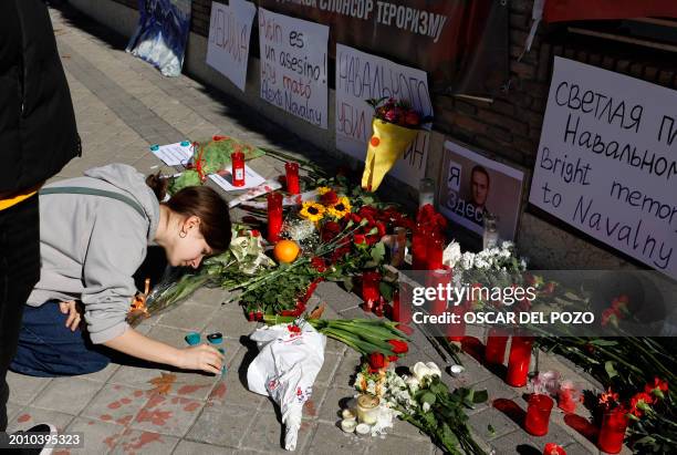 Woman lights a candle in front of the Russian embassy in Madrid on February 17 one day after Russian officials announced the death of the Kremlin's...