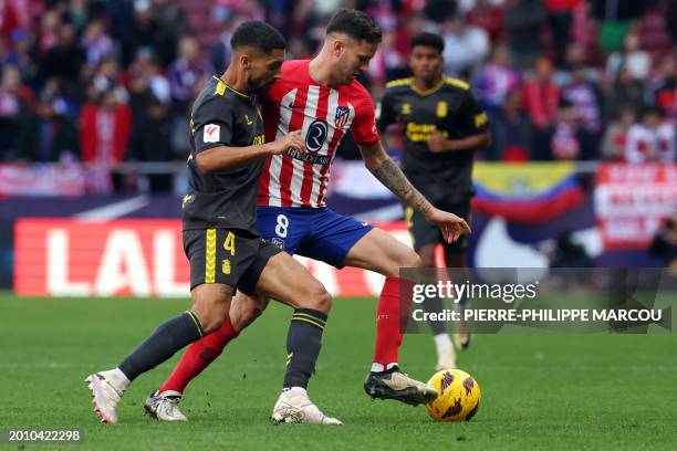 Las Palmas' Spanish defender Alex Suarez challenges Atletico Madrid's Spanish midfielder Saul Niguez during the Spanish league football match between...