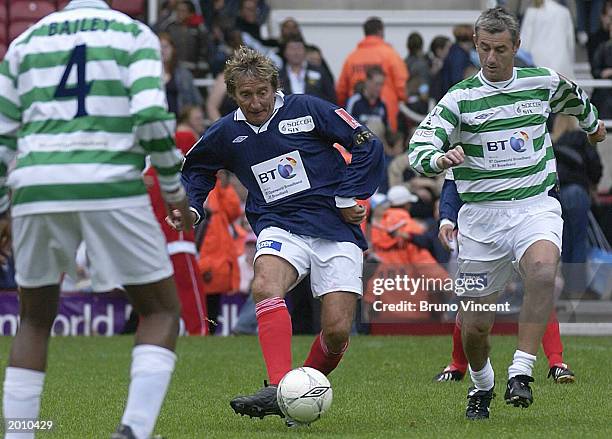 Former professional footballer Ian Rush challenges singer Rod Stewart for the ball in a match during the Music Industry Soccer Six Football...