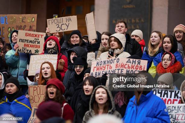 Activists shout slogans and hold banners denouncing corruption and urging higher city’s budget expenditures for military need during the rally ‘Money...