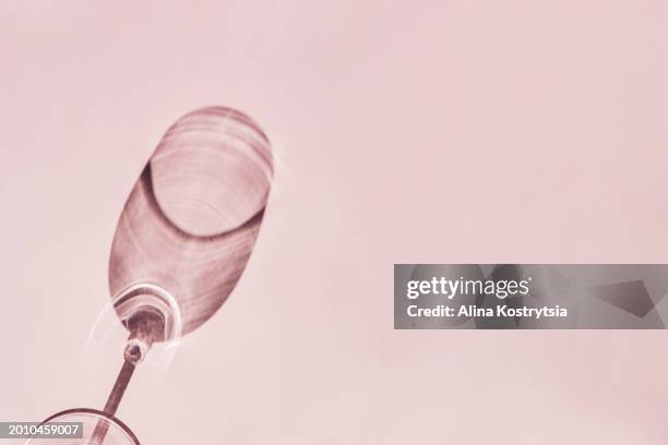 shadow from wine glass on pink background - empty glasses after party stock-fotos und bilder