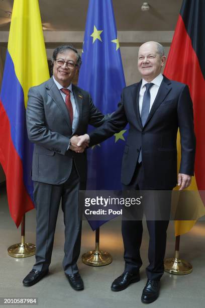 German Chancellor Olaf Scholz and Colombian President Gustavo Petro shake hands as they pose for media during bilateral talks at the 'Bayerischer...