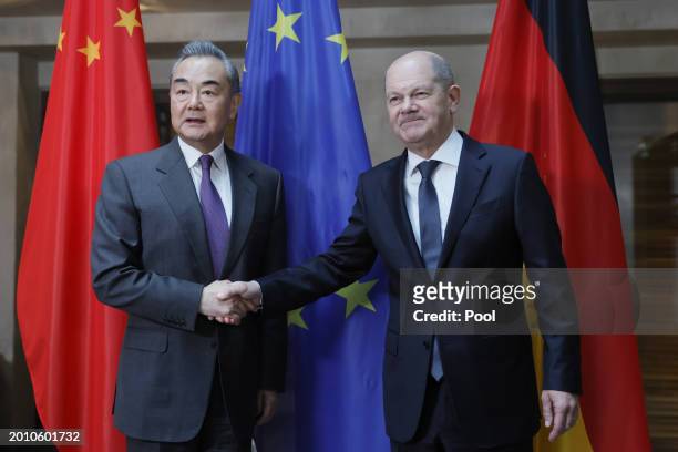 German Chancellor Olaf Scholz and Director of the Office of the Central Foreign Affairs Commission of the Chinese Communist Party Wang Yi shake hands...