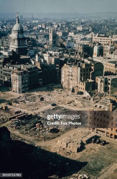 High-angle view of a bomb site which has been partially cleared after German bombing during the Blitz had destroyed several buildings, with St Paul's...