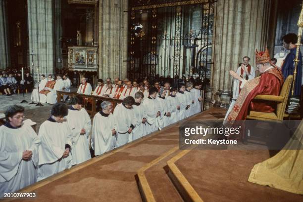 The Archbishop of Canterbury Robert Runcie conducts the Church of England's first ordination ceremony of women Deacons, held at Canterbury Cathedral,...