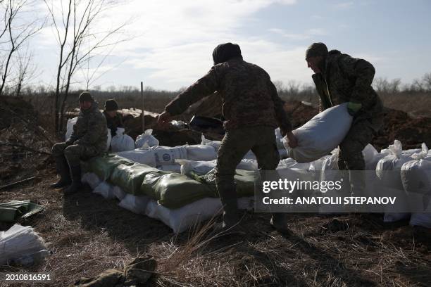 Ukrainian servicemen pile up earthbags to build a fortification not far from town of Avdiivka in the Donetsk region, amid the Russian invasion of...