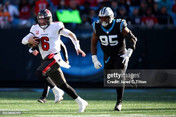 Baker Mayfield of the Tampa Bay Buccaneers scrambles away from Derrick Brown of the Carolina Panthers during the second half of the game at Bank of...