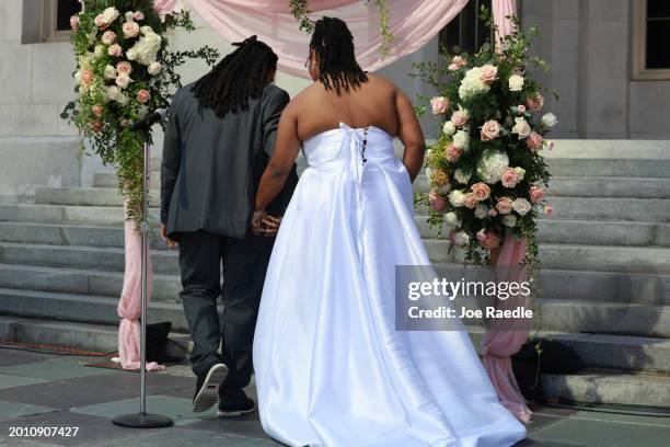 Shavarria Capers and Latraya Gray walk to the altar to be married during a Valentine's Day wedding ceremony on the steps of the Miami-Dade County...