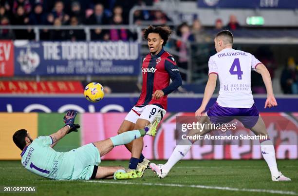 Joshua Zirkzee of Bologna FC shoots under pressure from Pietro Terracciano and Nikola Milenkovic of ACF Fiorentina during the Serie A TIM match...