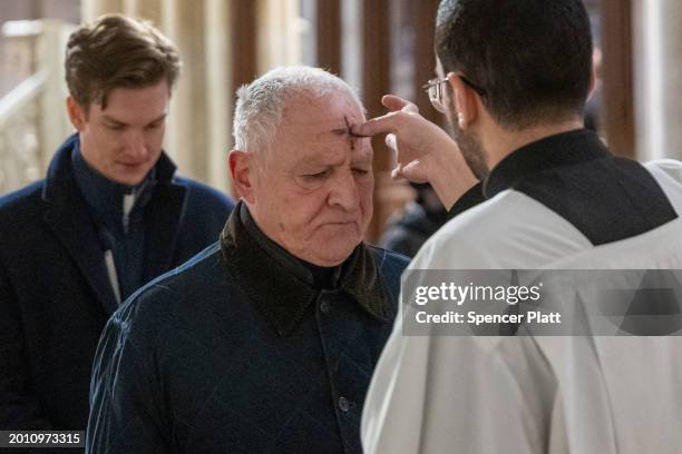 People get the sign of the cross placed on their forehead by a priest at St. Patricks Cathedral on Ash Wednesday on February 14, 2024 in New York...