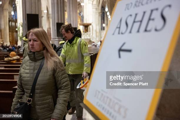 People exit after getting the sign of the cross placed on their forehead by a priest at St. Patricks Cathedral on Ash Wednesday on February 14, 2024...