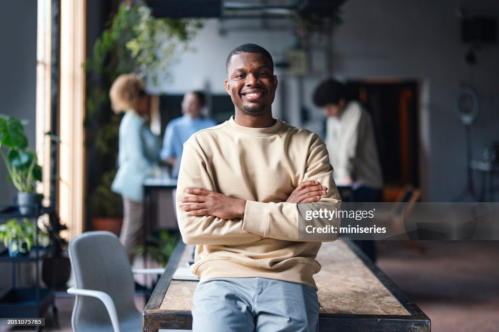 Confident Young Man Smiling in Casual Office Environment
