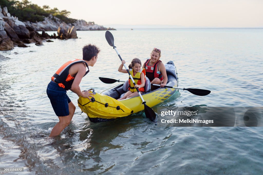 Family having fun with inflatable kayak on their summer vacation