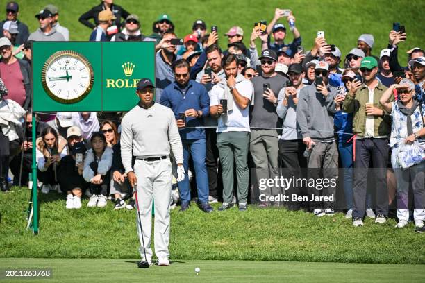 Tiger Woods prepares to play his shot from the 10th tee in front of the Rolex clock during the first round of The Genesis Invitational at Riviera...