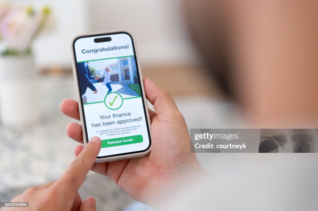Man holding a digital with mortgage loan application approval.