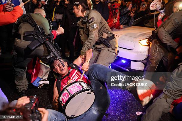 Israeli security forces dislodge a protester during an anti-government demonstration in Tel Aviv, on February 17 amid the ongoing conflict in the...