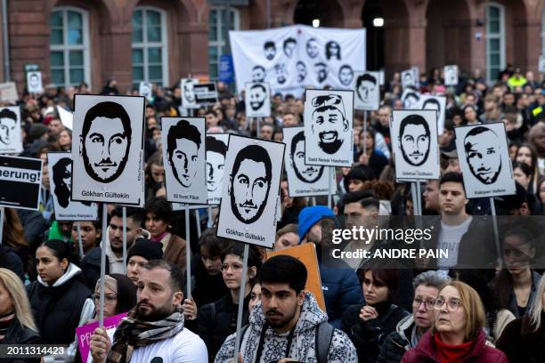 People holding portraits of the victims and banners against racism attend a protest march in commemoration of the deadly 2020 Hanau shootings four...