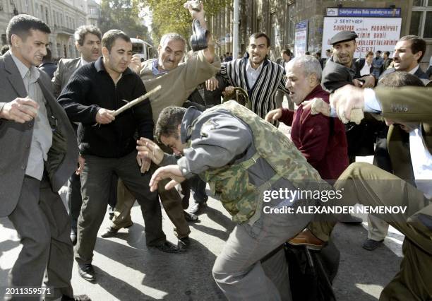 Supporters of Azeri opposition presidential candidate Isa Gambar kick a policeman in downtown Baku during riots, 16 October 2003, one day after...