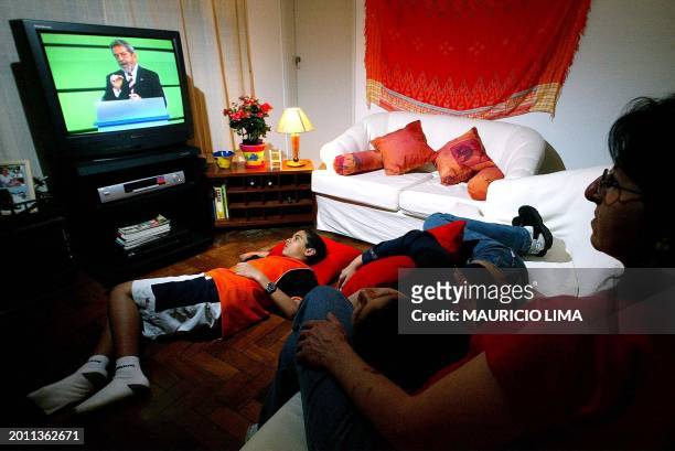 Una familia brasileña mira por la televisión, el 03 de octubre de 2002, el último debate entre los cuatro principales candidatos a la presidencia del...