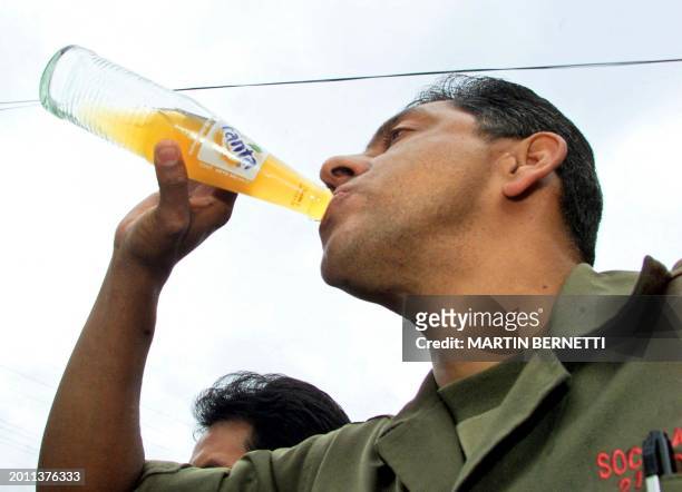 The Ecuatorian presidential candidate, the retired colonel Lucio Gutierrez, drinks a softdrink during a press conference in Quito 20 October 2002....