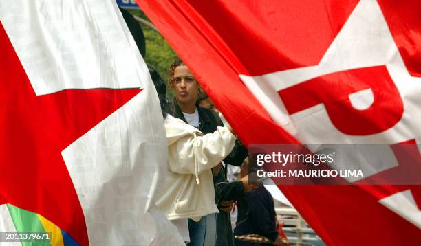 Girl stands between two flags of the worker's party of Brazil in the streets of Sao Paulo, 04 October 2002. A poll developed by the IBOPE institute...