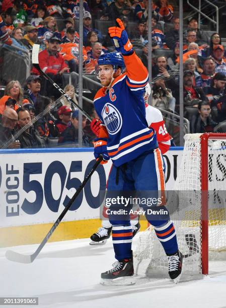 Connor McDavid of the Edmonton Oilers signals to the officials that the puck has gone out of play during the game against the Detroit Red Wings at...