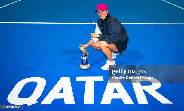 Iga Swiatek of Poland poses with the champions trophy after defeating Elena Rybakina of Kazakhstan in the singles final on Day 7 of the Qatar...