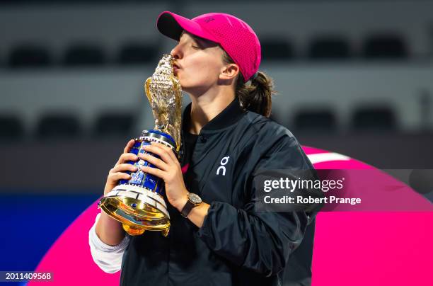 Iga Swiatek of Poland poses with the champions trophy after defeating Elena Rybakina of Kazakhstan in the singles final on Day 7 of the Qatar...