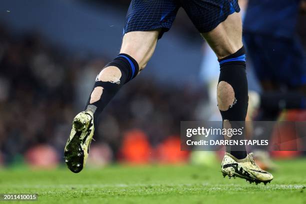 The socks covered in holes of Chelsea's English midfielder Conor Gallagher are pictured while he runs on the pitch during the English Premier League...