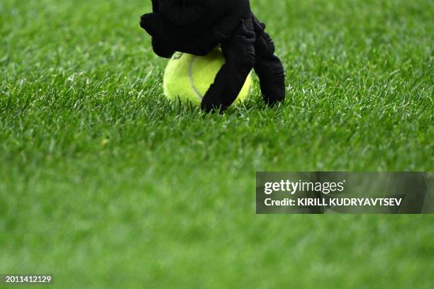 Staff member collects tennis balls thrown on to the pitch by fans protesting against the DFL during the German first division Bundesliga football...