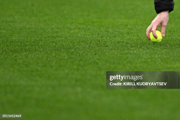 Staff member collects tennis balls thrown on to the pitch by fans protesting against the DFL during the German first division Bundesliga football...