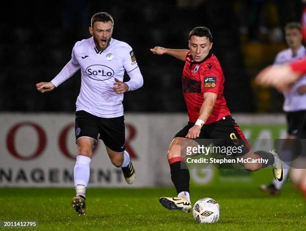 Longford , Ireland - 17 February 2024; Chris Lyons of Longford Town shoots to score his side's second goal despite the attention of David Cawley of...