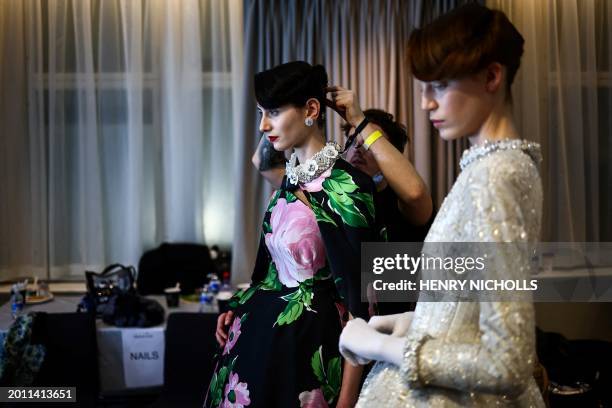 Model is prepared in the backstage ahead of a catwalk presentation by British designer Richard Quinn for his Autumn/Winter 2024 collection during...