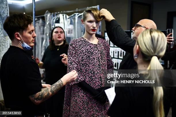 Model is prepared in the backstage ahead of a catwalk presentation by British designer Richard Quinn for his Autumn/Winter 2024 collection during...