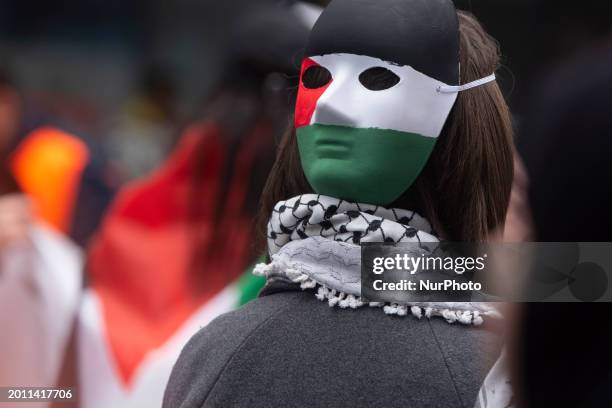 Protester wearing a Palestinian face mask is participating as hundreds of people join a pro-Palestine march against Israel's attacks on Gaza in...
