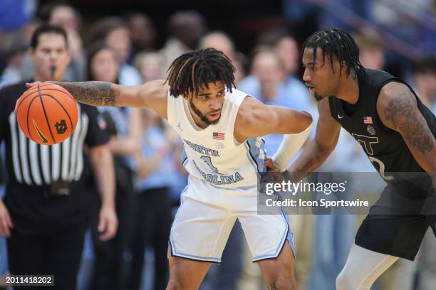 North Carolina Tar Heels guard RJ Davis holds for the clock as Virginia Tech Hokies guard MJ Collins defends during the college basketball game...