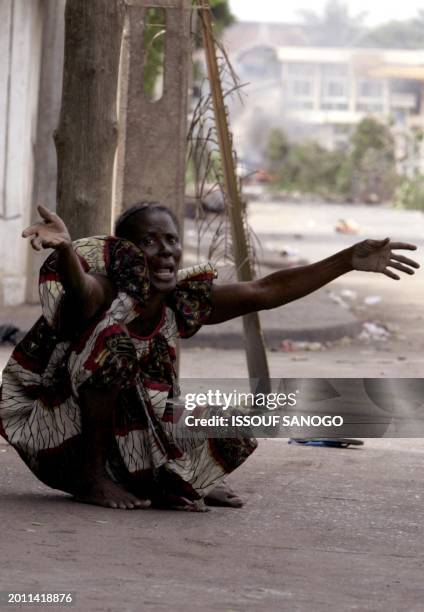 Woman calls for help outside her home in a district of Lome, 26 April 2005 following violent clashes with police forces that erupted after the...